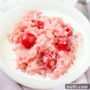 Cherry oatmeal with cherries and cream in a white bowl