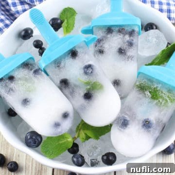 Blueberry Mojito Popsicles in a white bowl with ice