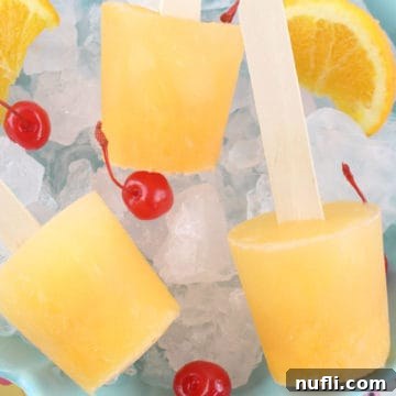 Screwdriver popsicles on a bed of ice with maraschino cherries
