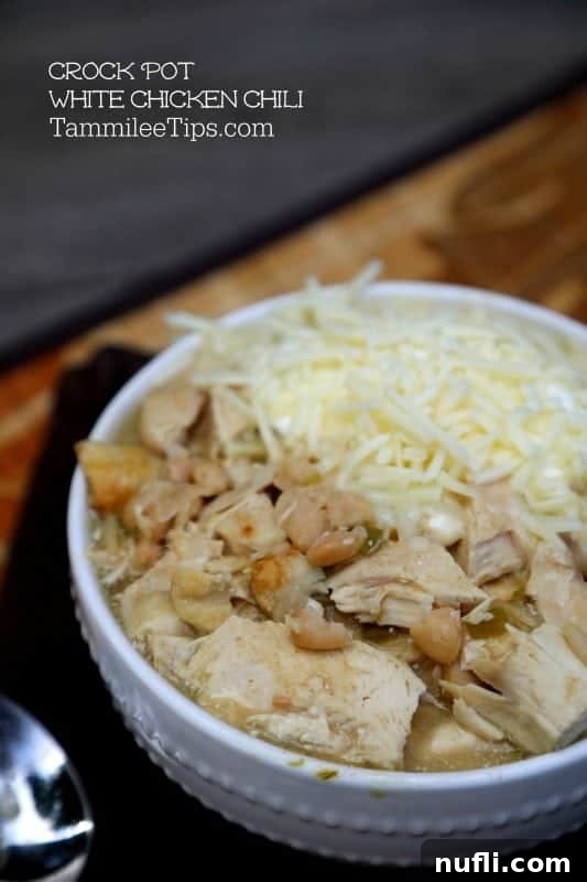 Creamy Crockpot White Chicken Chili garnished with fresh cilantro and shredded cheese, served in a white bowl