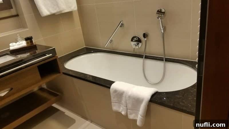 Lakeside Elegance in Killarney: The Europe Hotel 5 Modern bathroom with a sleek bathtub beside a contemporary sink and vanity cabinet at The Europe Hotel Killarney.