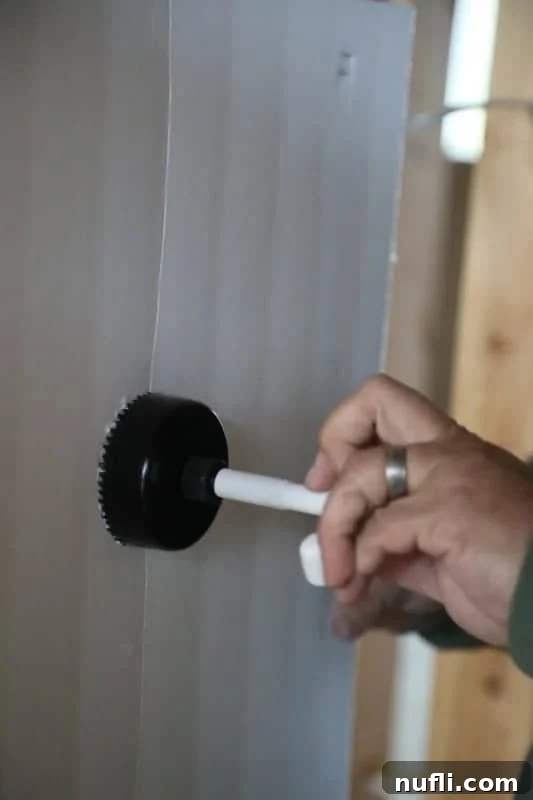 No More Tangled TV Cords: Legrand In-Wall Power Kit at Best Buy 3 Hand holding a tool to cut a circle into the wall