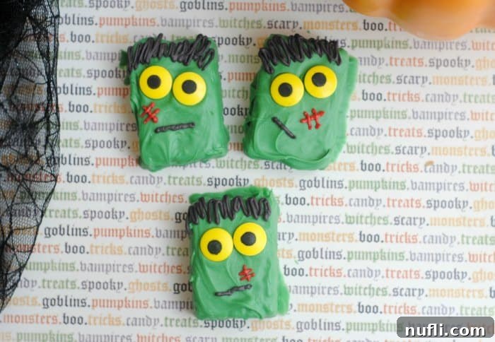 Frankenstein Rice Krispie treats displayed on festive Halloween paper