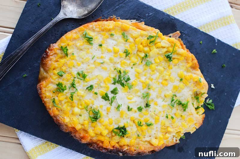 crockpot corn pudding on a blue placemat with a spoon