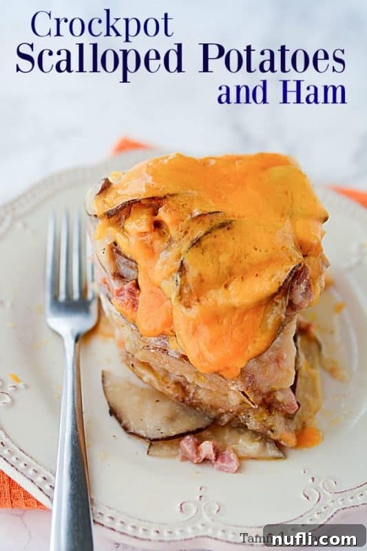 Scalloped Potatoes and ham next to a fork on a white plate