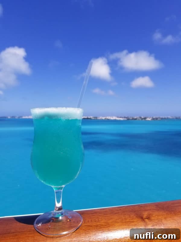 Vibrant Blue Margarita 6 Blue margarita in a hurricane glass with the tropical ocean in the background