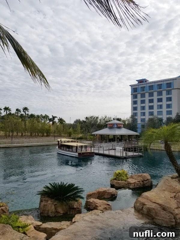 Water taxi approaching a dock near Loews Sapphire Falls Resort with lush tropical landscaping and resort buildings