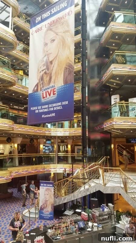 A wide shot of the elegant main lobby area on the Carnival Imagination, with seating and decorative elements.