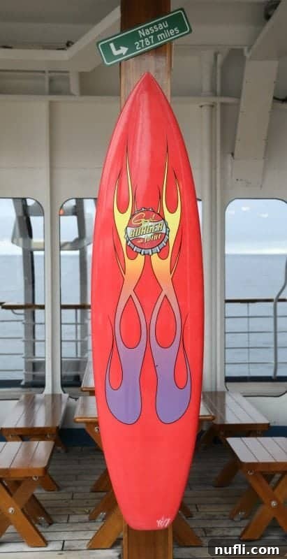 A red surfboard proudly displaying the Guy's Burger Joint logo, inviting guests to savor their delicious burgers.