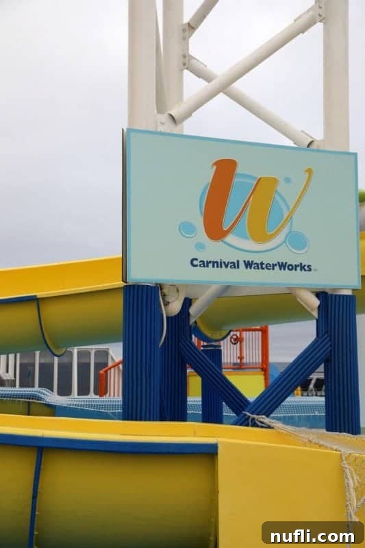 The vibrant yellow waterslide of Carnival WaterWorks on the Carnival Imagination, with a sign visible.
