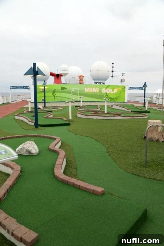 A colorful mini-golf course on the upper deck of the Carnival Imagination, with ocean views in the background.
