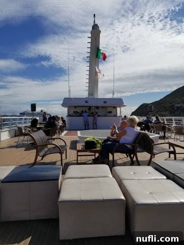 Passengers relaxing on the spacious top deck of a whale watching boat in Cabo, enjoying the views.