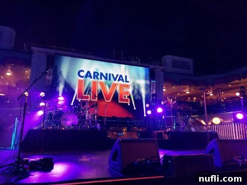The 'Carnival Live' logo prominently displayed on a large screen on a concert stage, highlighting the cruise line's entertainment program.
