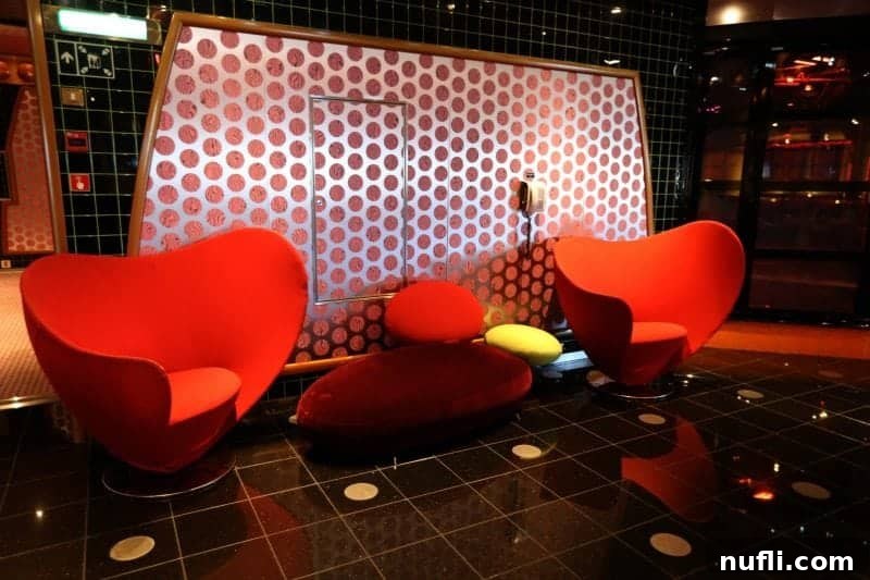 Charming red heart chairs near a polka dotted wall, showcasing playful decor.