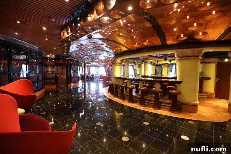 Inviting bar area with stools and stylish red chairs, perfect for casual conversations.