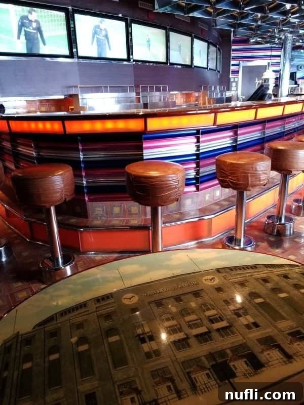 Carnival splendor sports bars with stools near the bar and numerous TVs on the wall, perfect for sports enthusiasts.