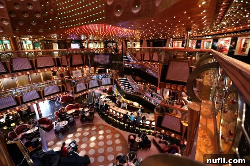 Overlooking the Carnival Splendor lobby with grand staircases and people sitting at the bar, bustling with activity.