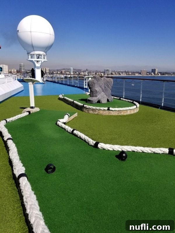 Mini golf course on the Carnival Splendor with the beautiful ocean in the background, offering scenic fun.