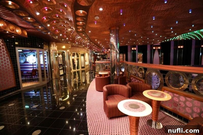 A vibrant walkway illuminated by colorful lights, with inviting tables and chairs on one side and enticing stores on the other.