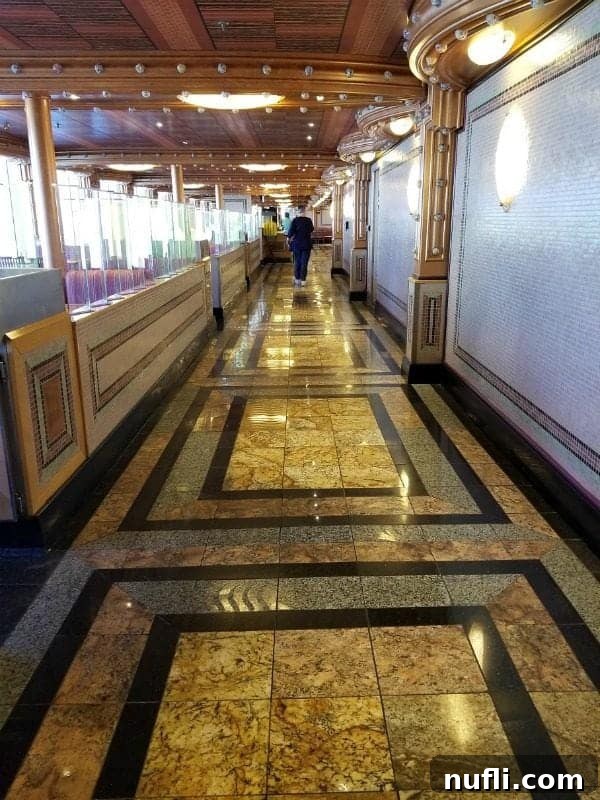 A wide, inviting walkway within the Carnival Splendor's Lido Deck area, with a person in the distance highlighting the generous space.