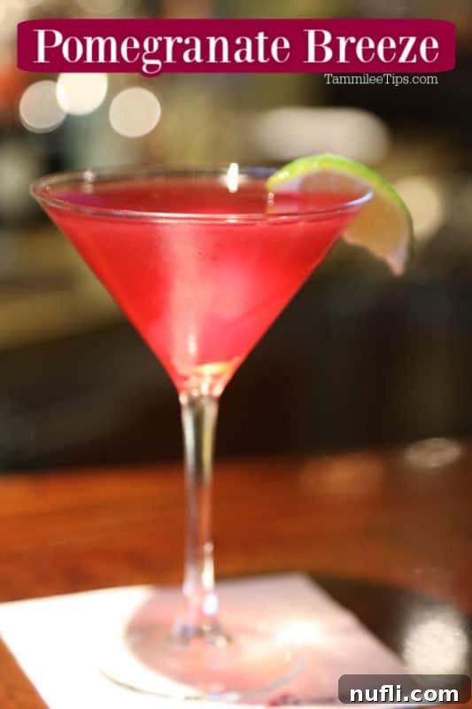 Refreshing Pomegranate Martini 2 A vibrant red Pomegranate Breeze Martini in a classic martini glass, garnished elegantly with a lime slice, evoking a sense of refreshing luxury.