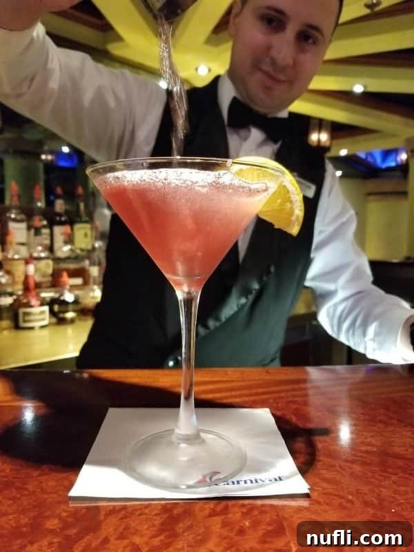 Golden Hour Island Martini 4 Bartender pouring a Caribbean Sunset Martini into a martini glass sitting on a white napkin