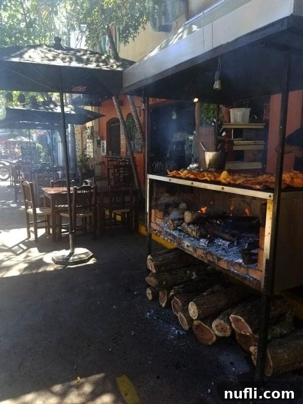 chicien being cooked over an open fire next to a restaurant 