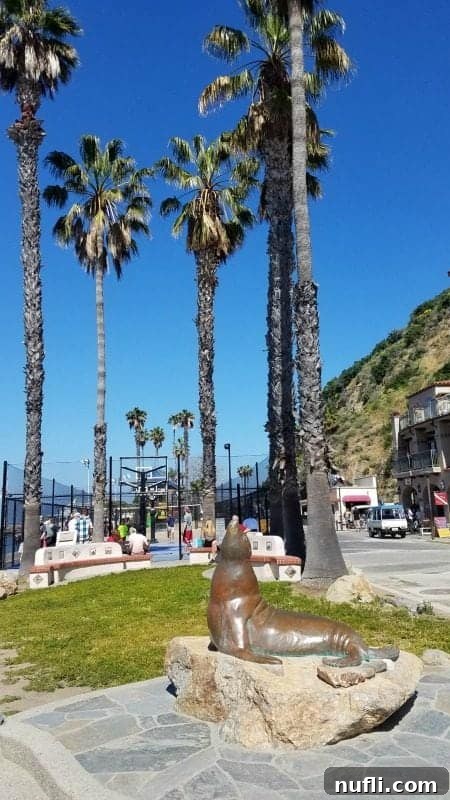 A playful seal statue stands prominently against a backdrop of swaying palm trees and a vibrant basketball court, capturing the lively and relaxed atmosphere of Catalina Island.