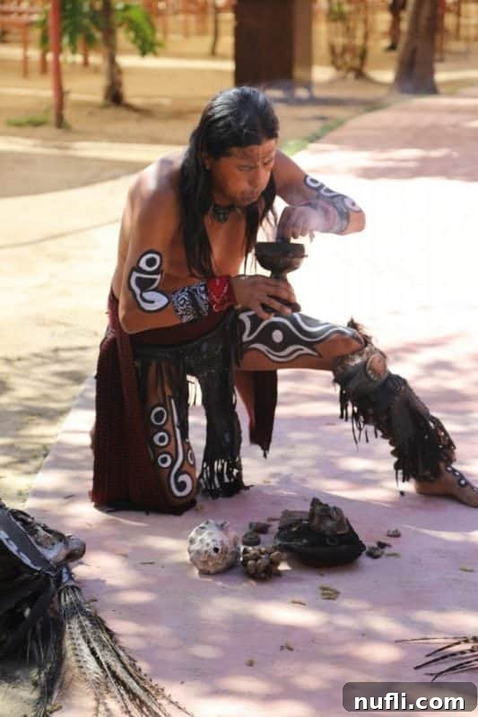 man dressed in regalia blowing on smoke