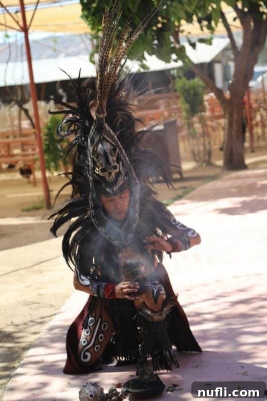 man dressed in feather regalia blowing smoke