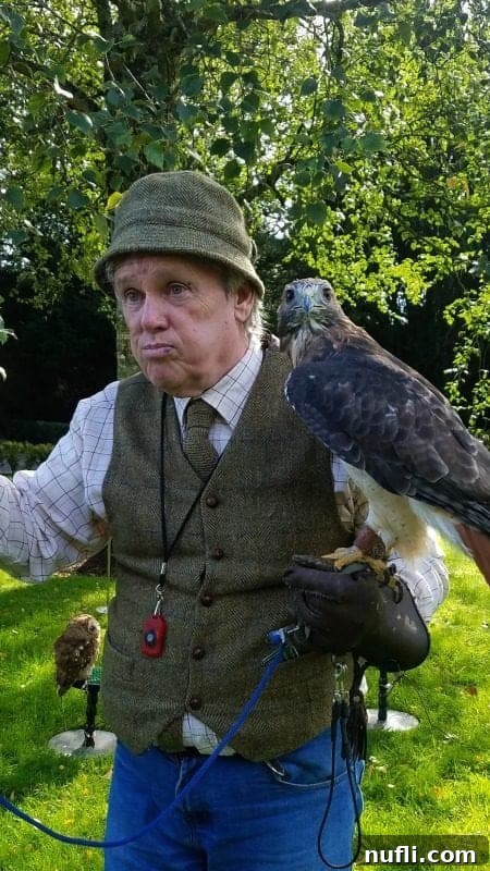 gentleman holding a falcon on a glove 