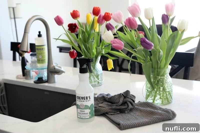 Tulips on a white counter with Mrs Meyers Clean Day products and grey towels