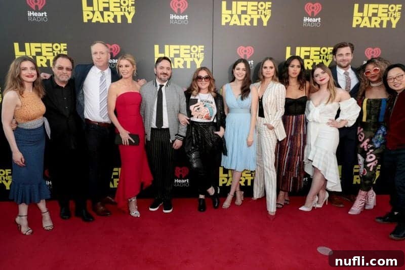 The full cast and crew of 'Life of the Party' including Gillian Jacobs, Stephen Root, Matt Walsh, Julie Bowen, Ben Falcone, Melissa McCarthy, Molly Gordon, Debby Ryan, Adria Arjona, Jessie Ennis, Luke Benward, Yani Simone, and Jimmy O. Yang, gathered in front of the movie's premiere sign.