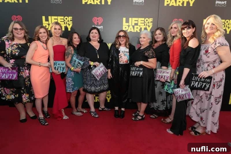 A group of smiling women, including Tammilee, posing happily with Melissa McCarthy in front of a prominent 'Life of the Party' movie premiere sign on the red carpet.