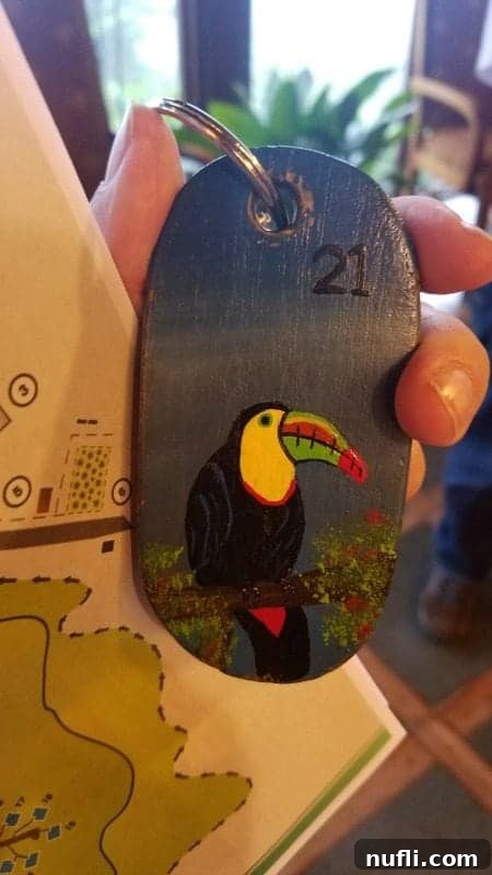 A small, intricately painted keychain featuring a vibrant toucan, a popular emblem of Costa Rica's rich avian life.