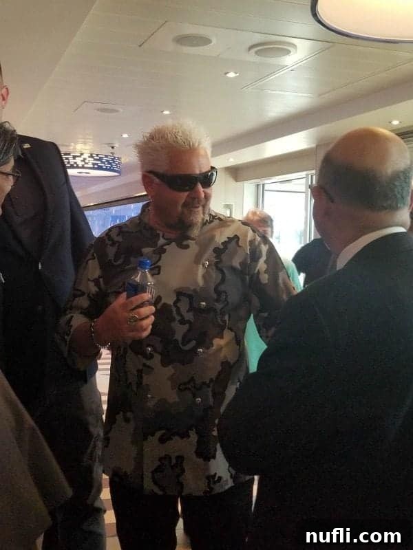 Celebrity Chef Guy Fieri in a camouflage chef's jacket smiling proudly at the grand opening of the Pig & Anchor Smokehouse and Brewery