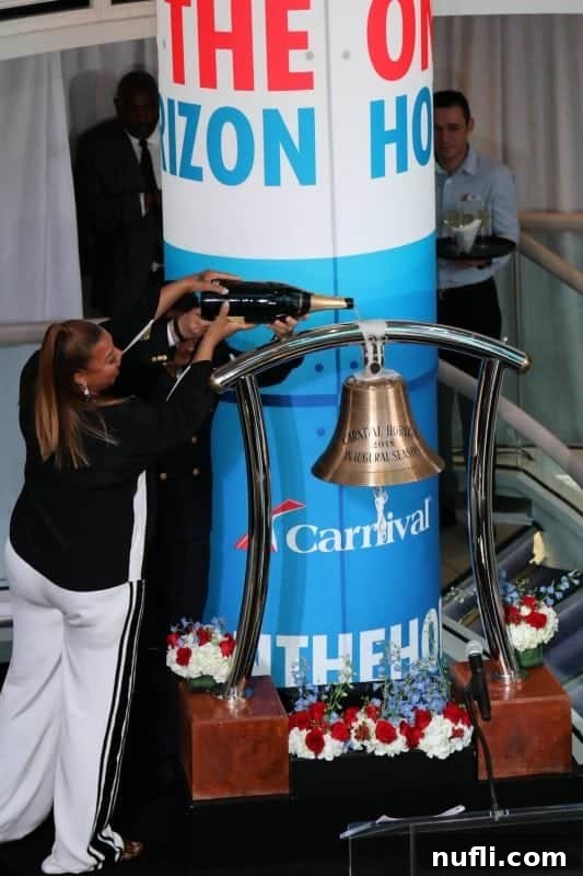 Queen Latifah gracefully pouring a large bottle of champagne over the ship's bell during the Carnival Horizon Naming Ceremony