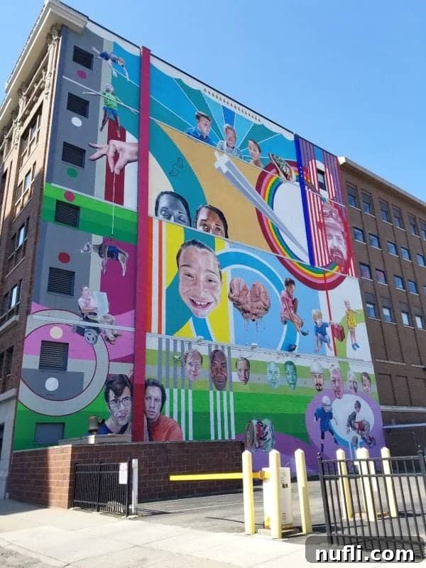 Colorful mural with kids playing on the side of a building in Grand Rapids