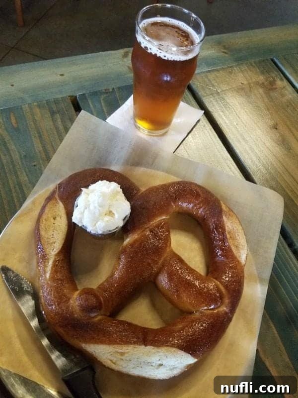 Beer glass next to a giant pretzel