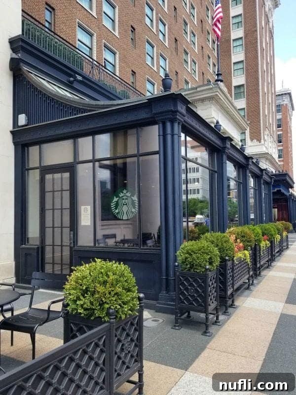 Starbucks logo visible through a glass window with an open entrance door at the Amway Grand Plaza, offering convenient coffee access