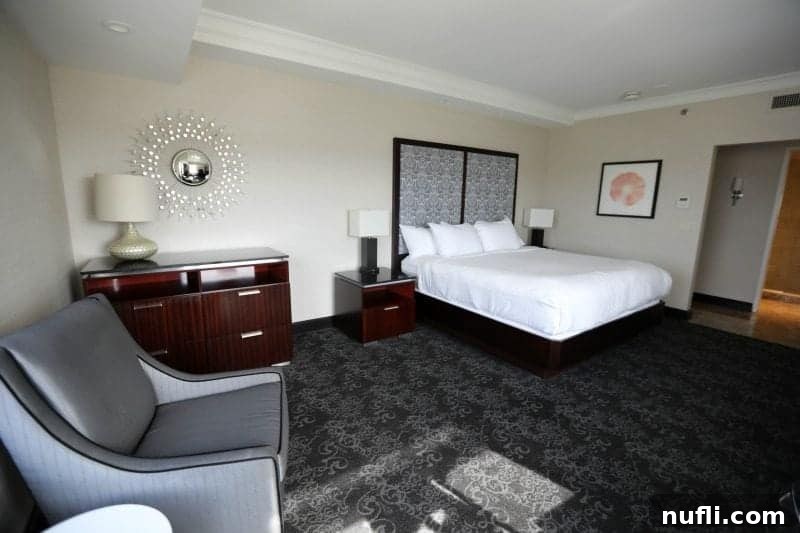 Comfortable hotel room with a king bed, dresser, and armchair at the Amway Grand Plaza