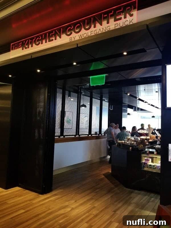 The Kitchen Counter by Wolfgang Puck restaurant sign above a stylish entrance, signaling a gourmet dining experience