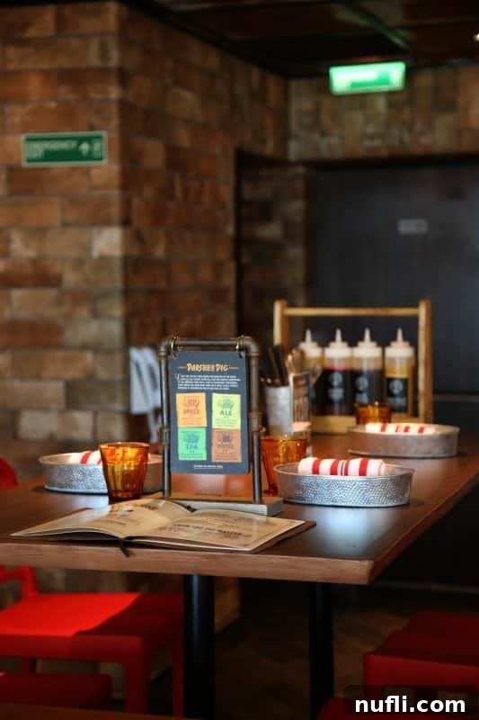 A table setting at Pig & Anchor, complete with signature barbecue sauces, napkins, and cutlery, ready for a delicious feast.