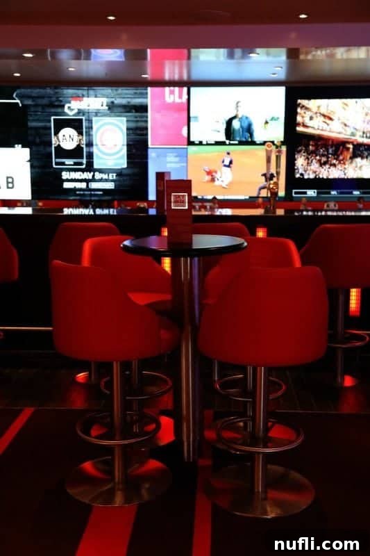 The lively Sports Bar on Carnival Horizon, with tall red chairs, tables, and multiple TVs displaying sports events.