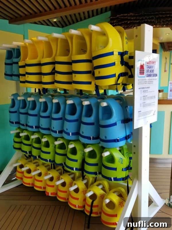 A close-up view of life jackets neatly displayed at the loaner station, ready for use by young cruisers.