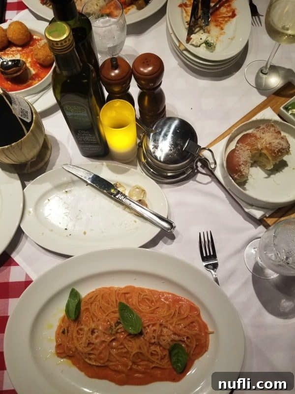 A beautifully presented plate of fresh pasta with bread and olive oil, inviting guests to savor the Italian delights at Cucina Del Capitano on Carnival Horizon.