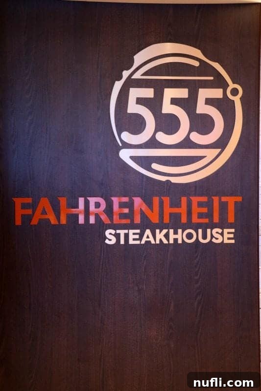An illuminated Fahrenheit 555 Steakhouse sign with elegant branding, inviting guests to a premium dining experience on Carnival Horizon.