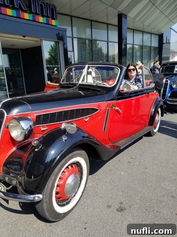 Tammilee sitting in a historic convertible 