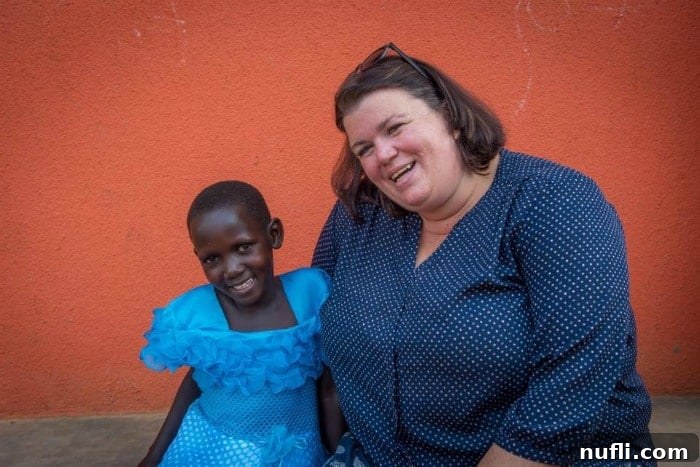 Tammilee Tillison engaging with a child in a rural Ugandan community, symbolizing the personal connection World Vision fosters.