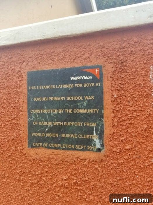 A sign pointing to new latrines built by World Vision, emphasizing improved sanitation in Ugandan communities.